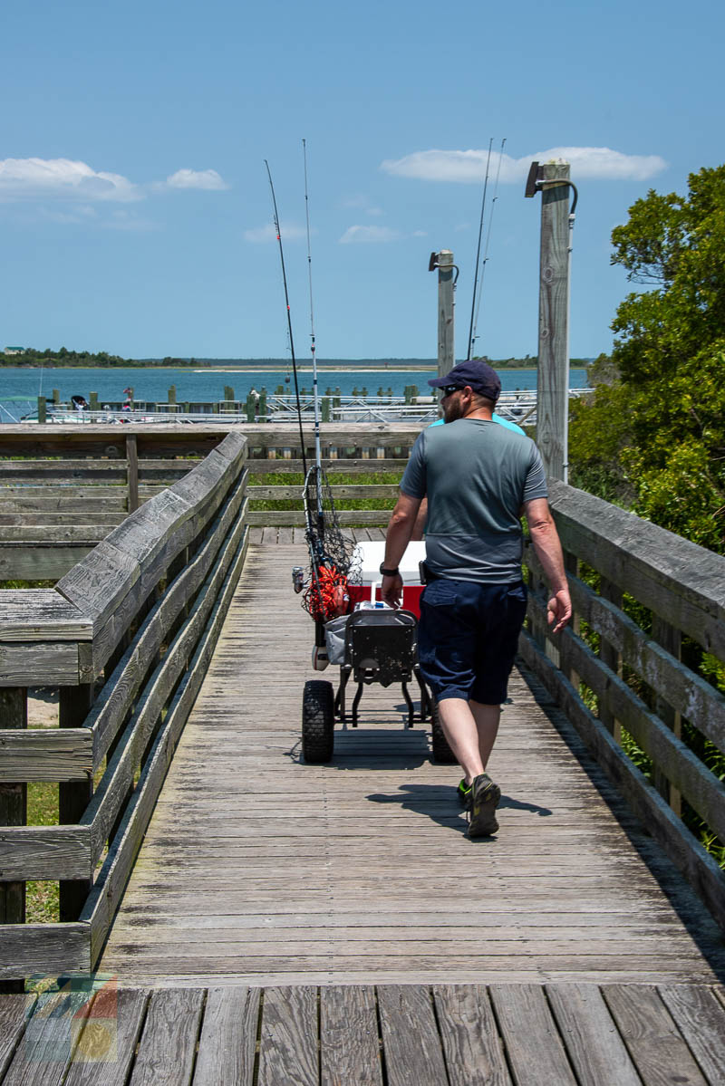 Fisherman walking onto Newport River Pier